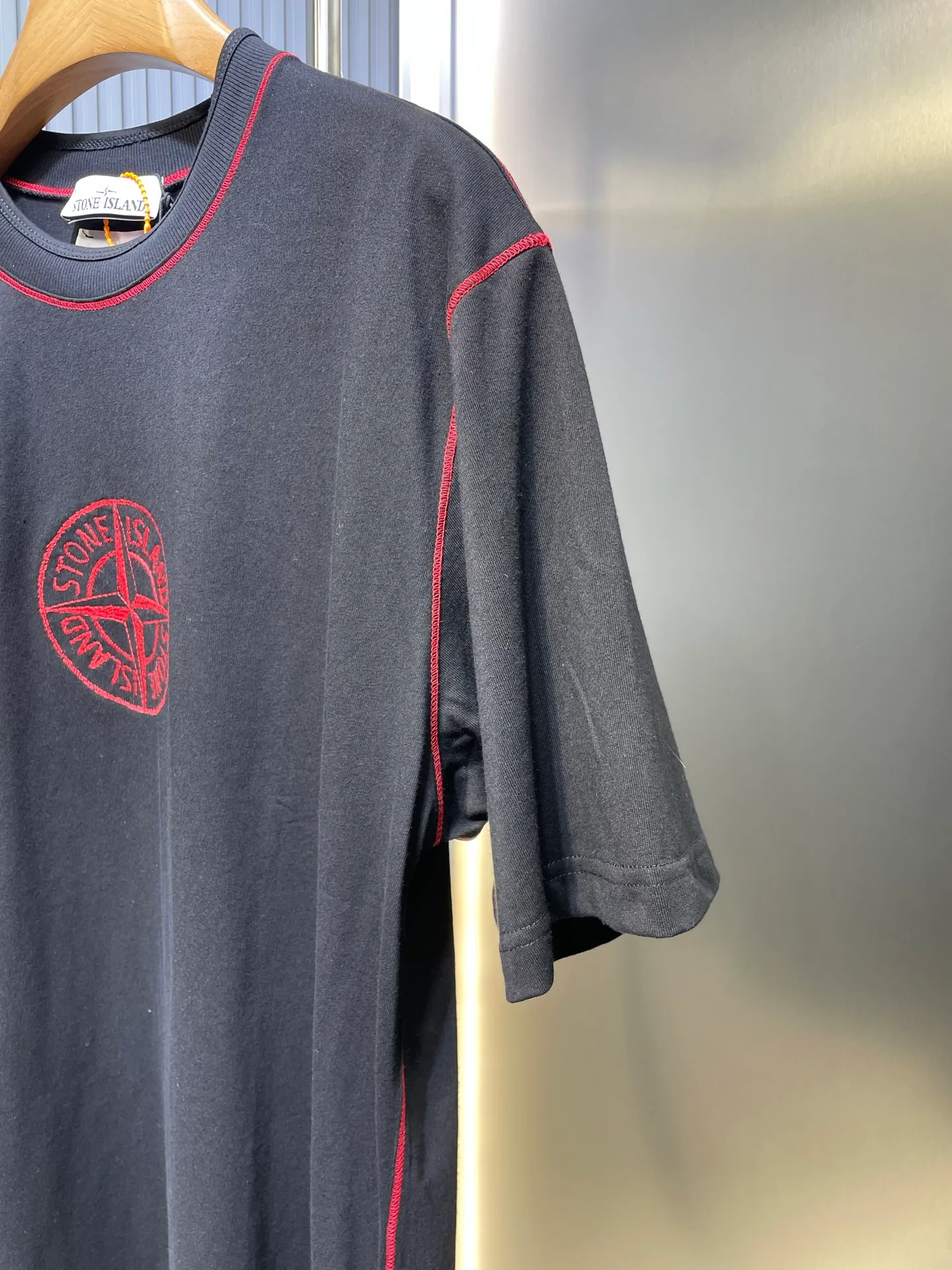 🅿️280 Stonelsland badge embroidered short sleeves. Customized elegant black silk cotton and linen plain fabric. Delicate and smooth, comfortable and skin-friendly. The iconic red Compass badge embroidery on the chest highlights the brand's imprint. Stitch art. The beauty of contrasting colors. The red stitches jump on the black base. The collision of fashion and creativity exudes irresistible charm. Process 1: Using imported machine embroidery technology, using advanced computer control systems and precision mechanical components to realize the red Compass badge embroidery operation. High precision, smooth and delicate lines. Process 2: Special machine for back-bottomed topstitch fine sewing. Special machine is used for topstitch sewing. The reverse side of the clothing is required to be carefully prepared before sewing. Ensure straight sewing lines, even stitches, smooth edges and beautiful appearance. Process 3: The fabrics are washed and have a better hand feel. Not easy to deform, not easy to shrink, not easy to fade, and maintain long-term beauty. Accessories: Customized 1:1 Stonelsland trademark. Version: Loose fit Size: S M L XL Style number: 25142-A20